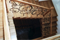 Дубовая лестница с кованым ограждением, покрытая лаком