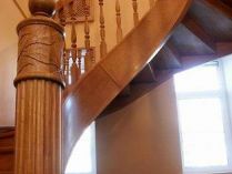 Дубовая винтовая лестница на шпонированной тетиве. Столб выполнен с резьбой и канелюрами