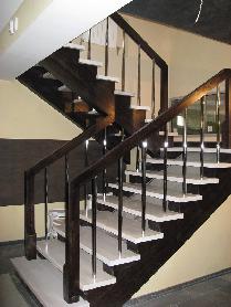 Лестница из массива ясеня с металлическими балясинами и белесыми ступенями. Поручень и косоур покрашены в цвет «Венге»